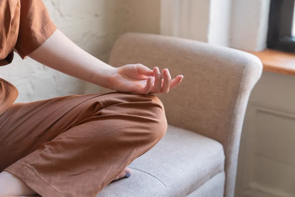 Person sitting calmly outdoors in a moment of mindfulness